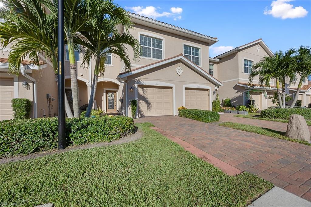 a front view of a house with a garden and trees