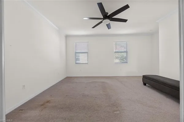an empty room with a ceiling fan and window