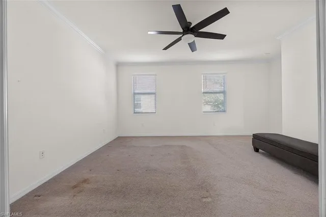 an empty room with a ceiling fan and window
