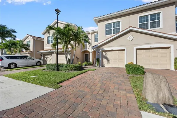 a front view of a house with a yard and potted plants