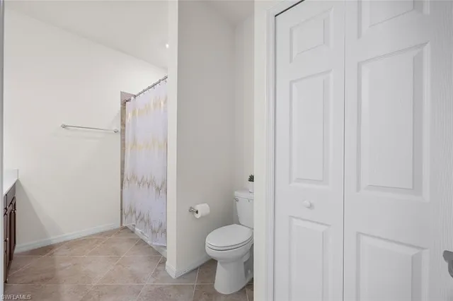 a bathroom with a granite countertop toilet and a shower