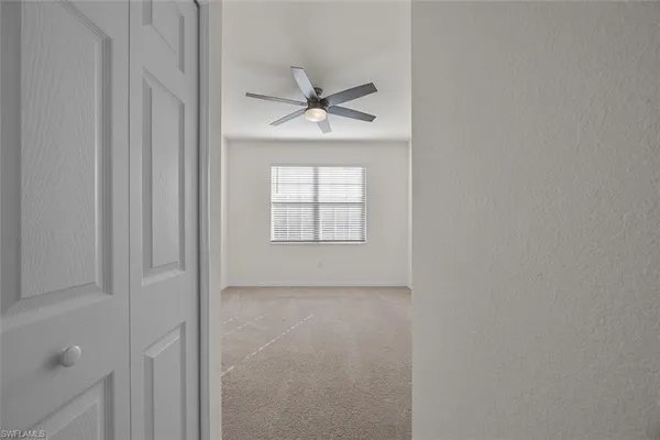 an empty room with windows and fan