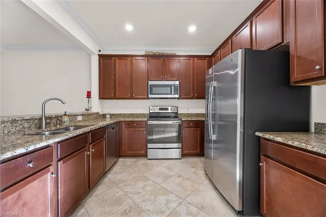 a kitchen with granite countertop stainless steel appliances and refrigerator