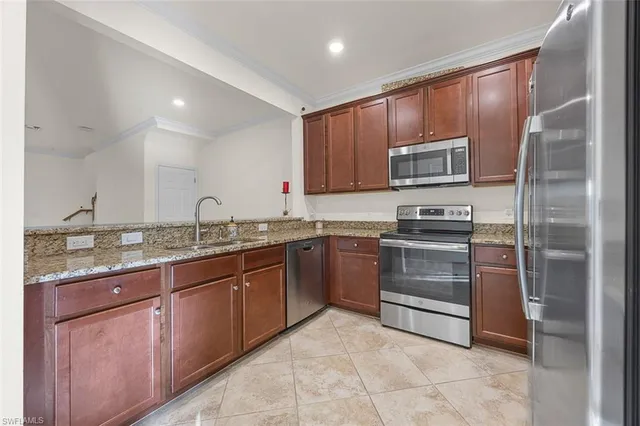 a kitchen with kitchen island granite countertop a stove microwave and refrigerator