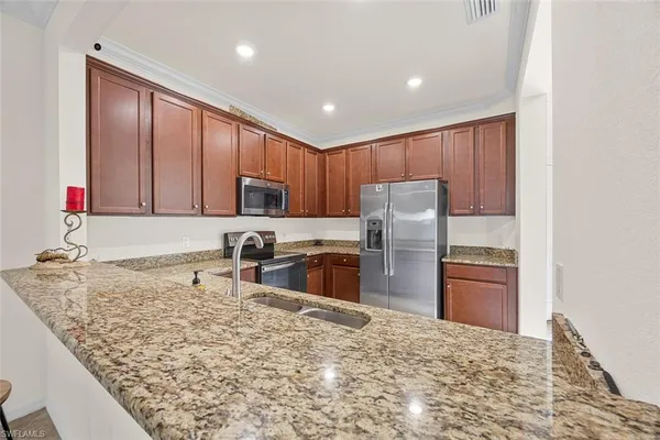 a kitchen with stainless steel appliances granite countertop a refrigerator sink and stove