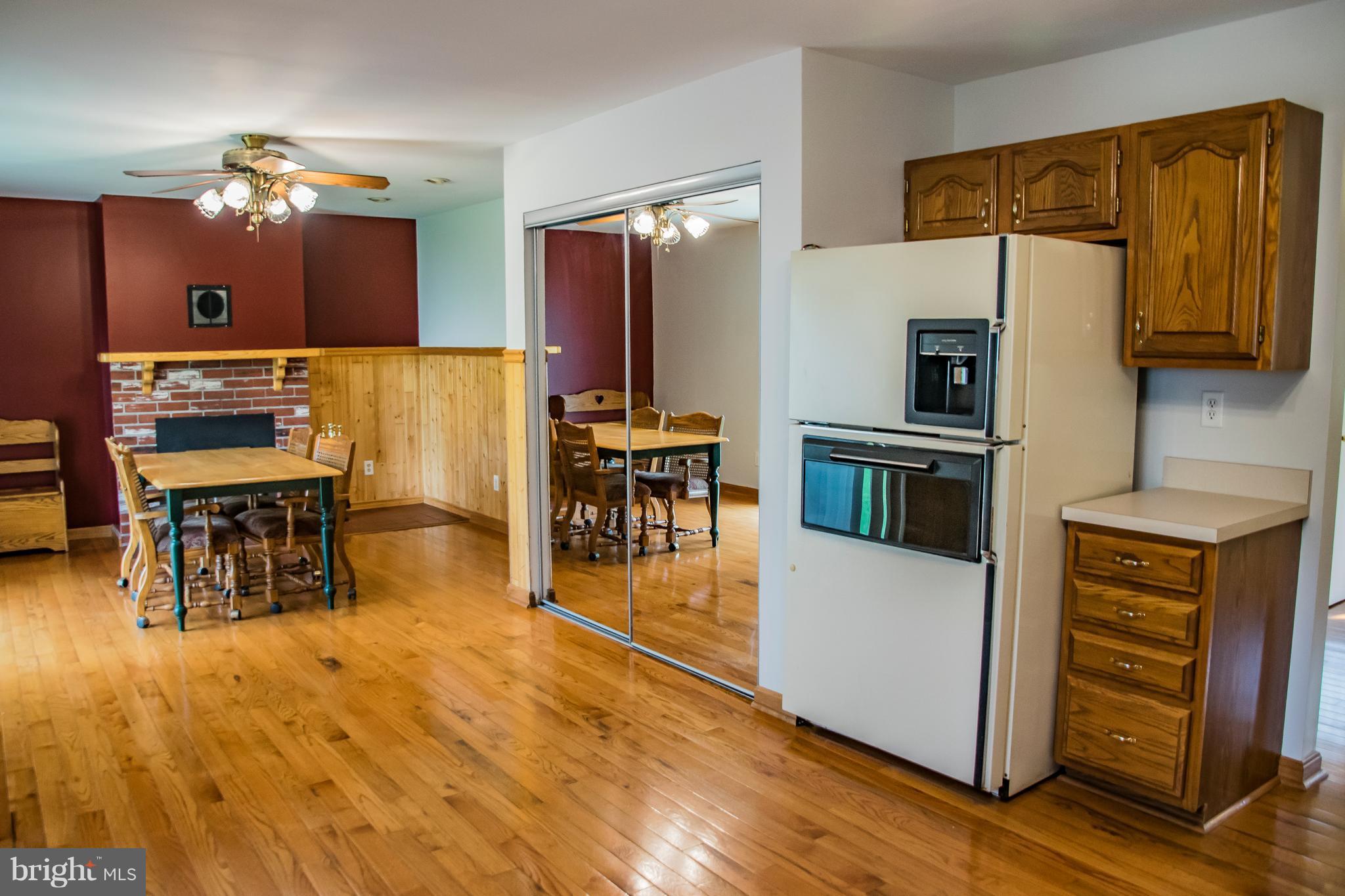 1403 Spring Avenue Baltimore, MD 21237 - Photo 6 of 28 a kitchen with stainless steel appliances wooden floor dining table and chairs