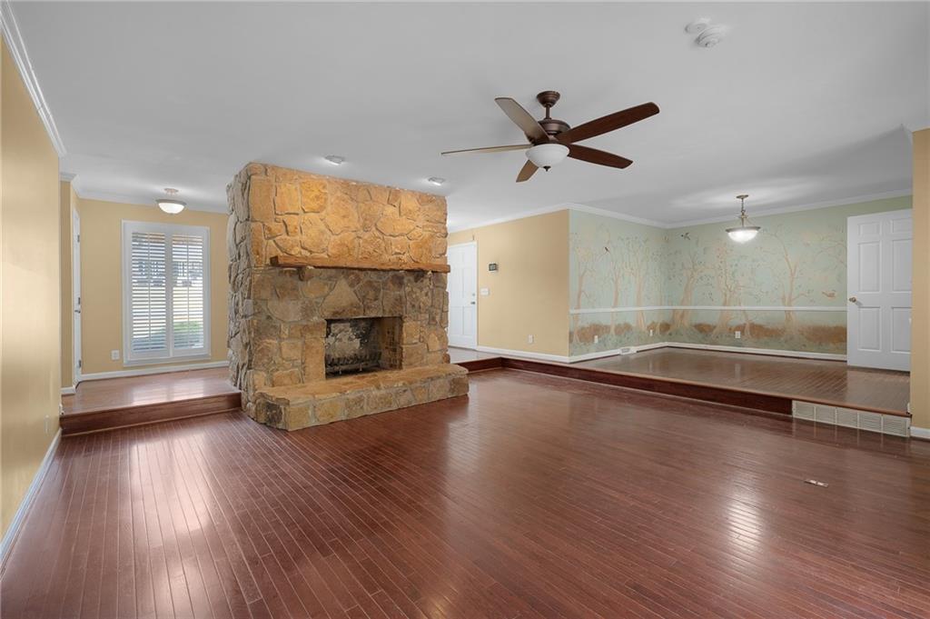 127 Windsor Drive Calhoun, GA 30701 - Photo 11 of 57 an empty room with wooden floor a fireplace and windows