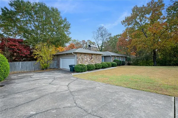 a front view of a house with a yard and trees