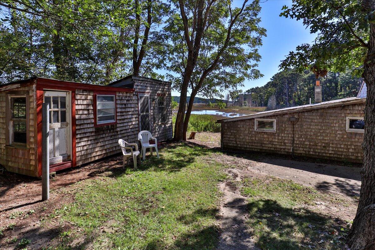 5 Indian Neck Road Wellfleet, MA 02667 - Photo 10 of 24 a view of backyard with wooden fence and a large tree