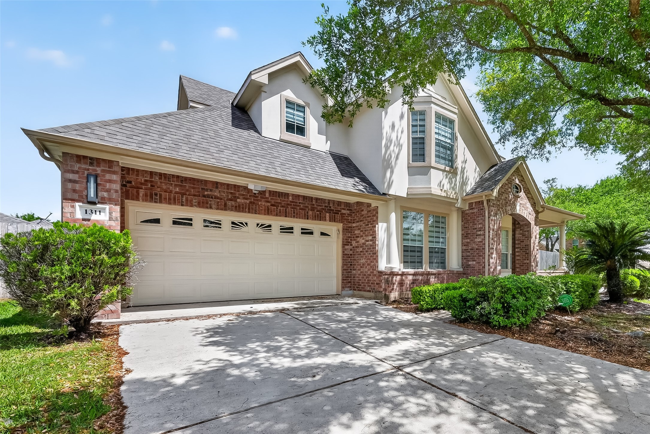1311 Rene Court Sugar Land, TX 77479 - Photo 2 of 45 This inviting two-story home features a classic brick exterior with a modern touch. It includes a spacious two-car garage and a well-maintained front yard with lush greenery. The large windows allow plenty of natural light, enhancing its welcoming appeal. Ideal for comfortable family living.