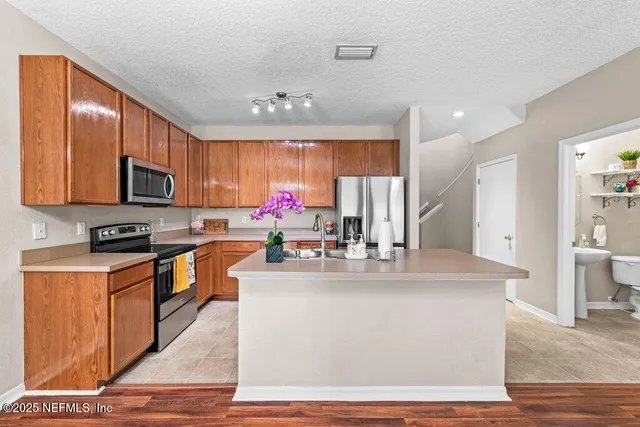 a kitchen with a stove a refrigerator and a sink