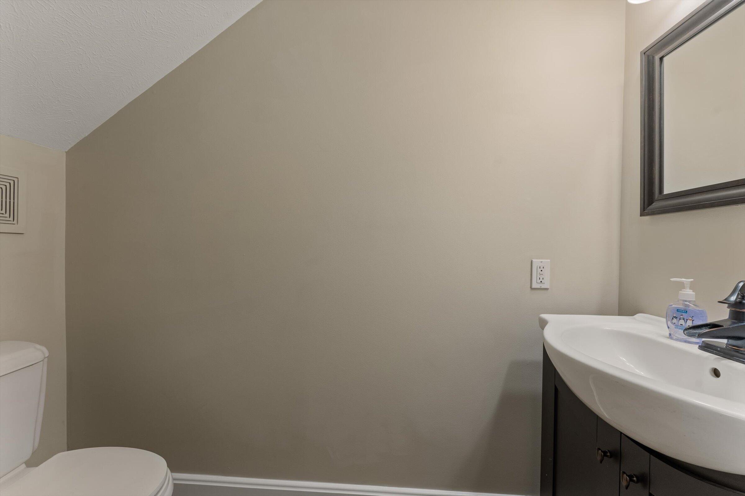 7692 North Emery Road Rolling Prairie, IN 46371 - Photo 27 of 69 a bathroom with a sink a toilet and mirror