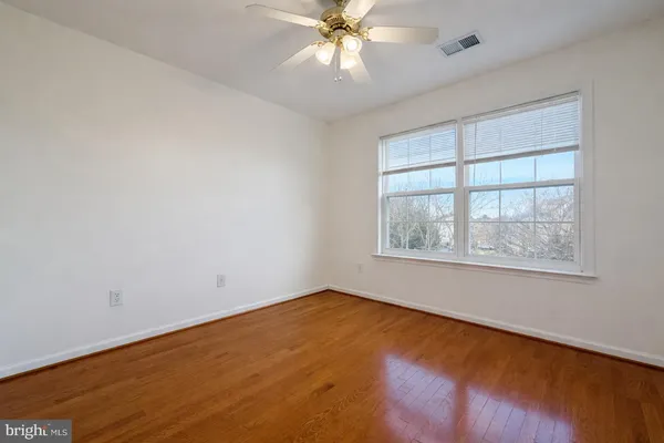 an empty room with a window and a fan