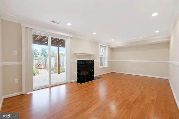 a view of empty room with wooden floor and fireplace