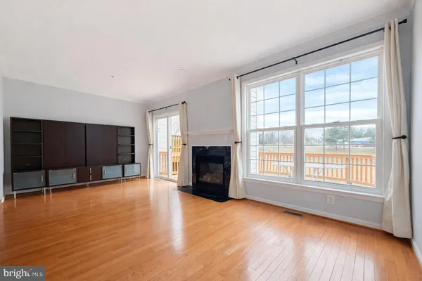 wooden floor fireplace and windows in an empty room