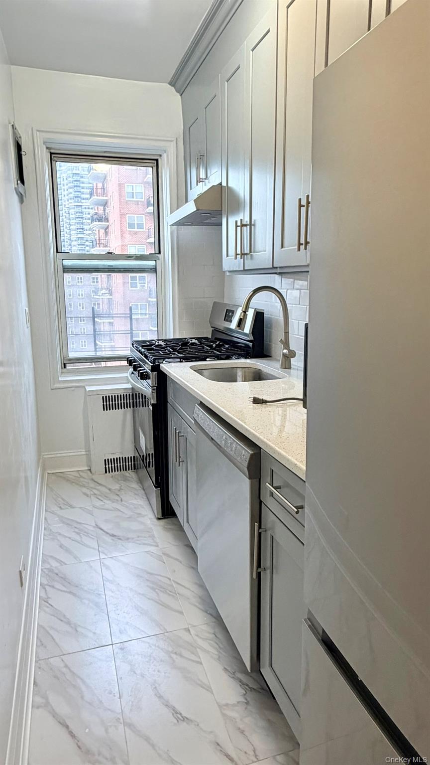 112-15 72nd Road, Unit 602 Queens, NY 11375 - Photo 3 of 12 a kitchen with stainless steel appliances granite countertop a sink stove and cabinets