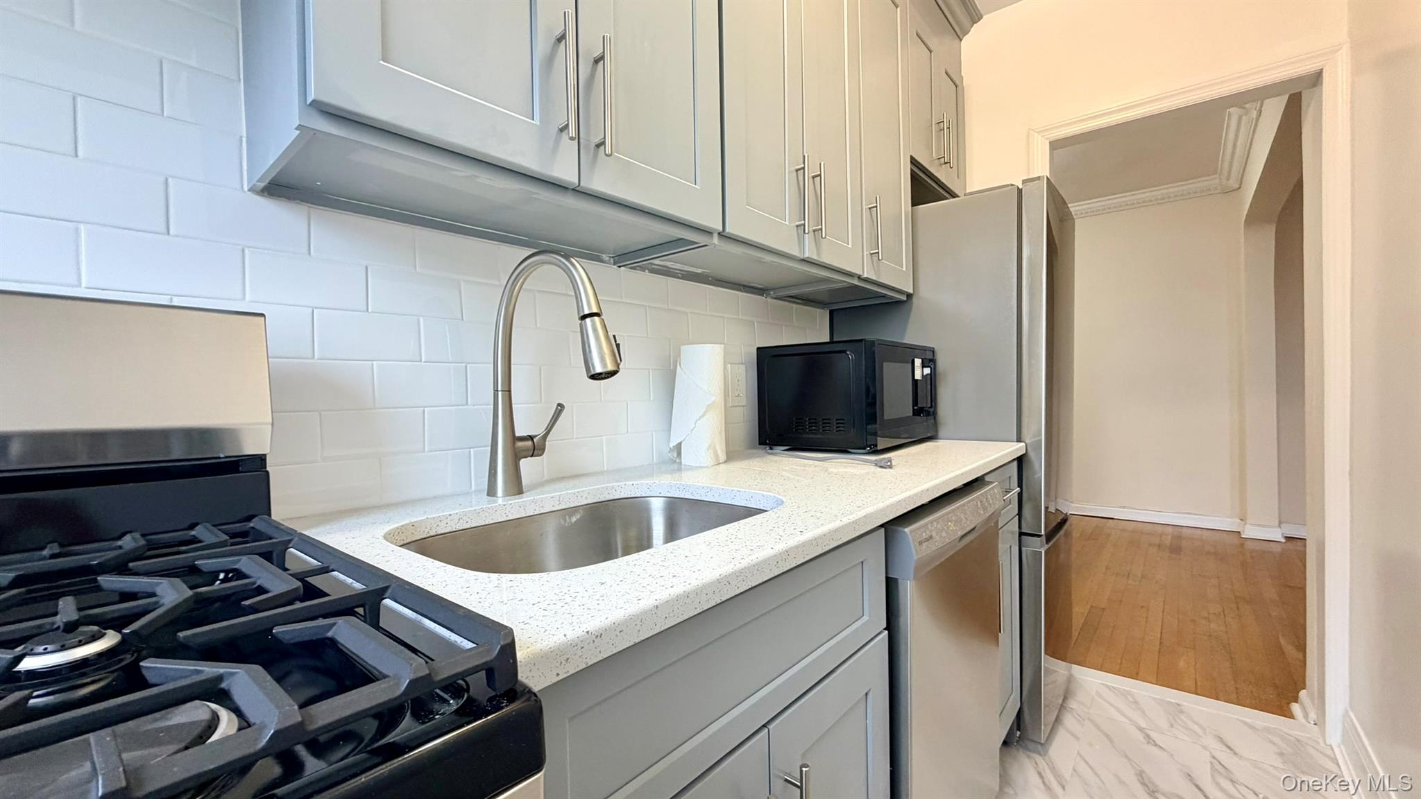 112-15 72nd Road, Unit 602 Queens, NY 11375 - Photo 5 of 12 a kitchen with a stove and a sink