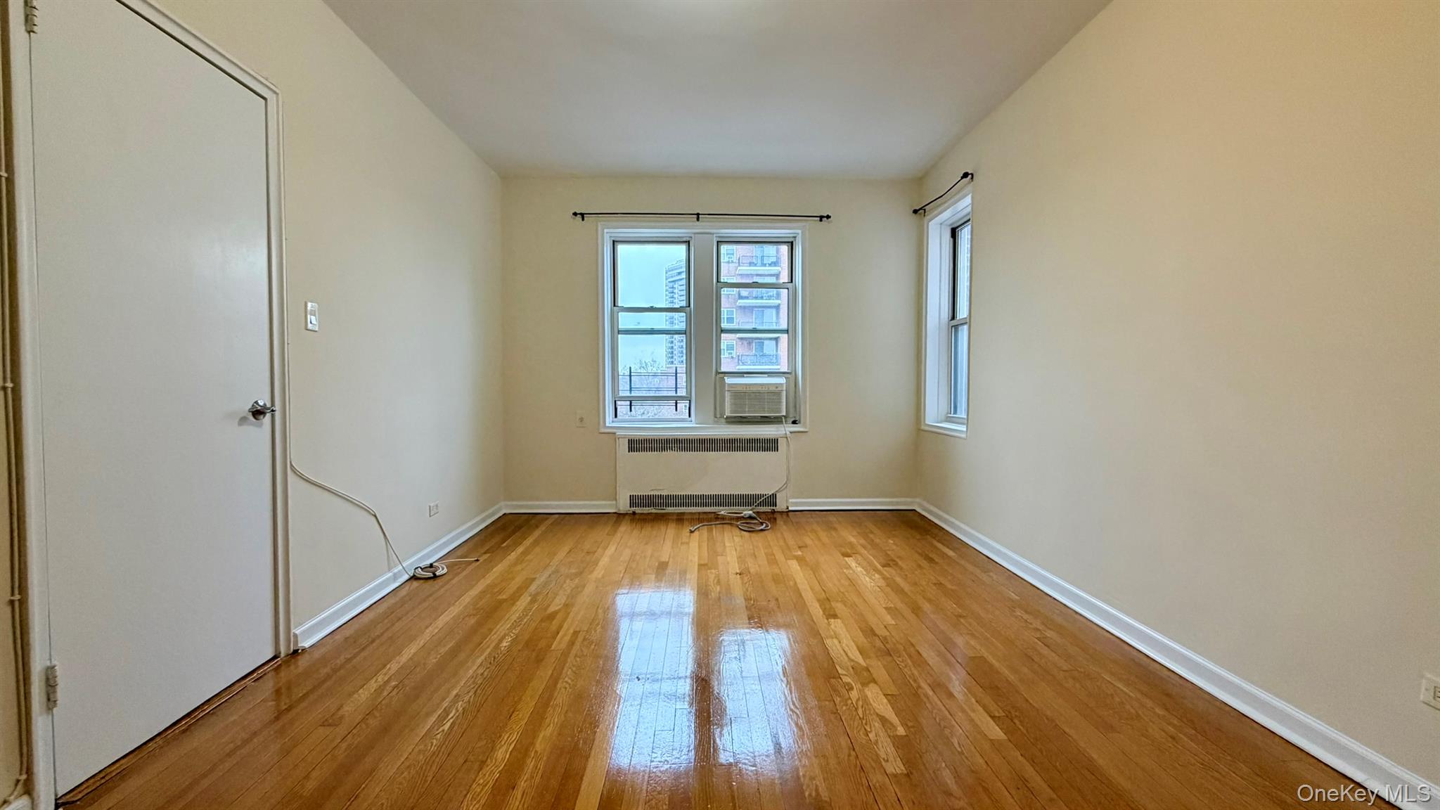 112-15 72nd Road, Unit 602 Queens, NY 11375 - Photo 6 of 12 a view of an empty room with wooden floor and a window