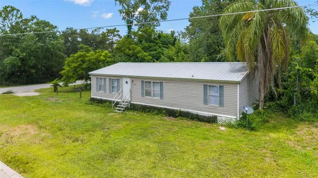 a aerial view of a house with a yard table and chairs