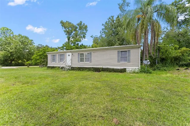 an aerial view of residential houses with outdoor space and trees