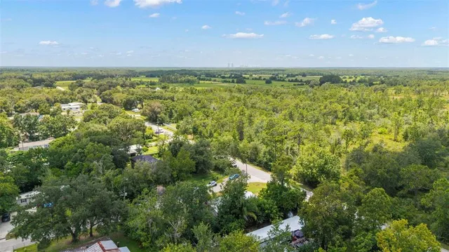 a aerial view of a house next to a big yard with large trees