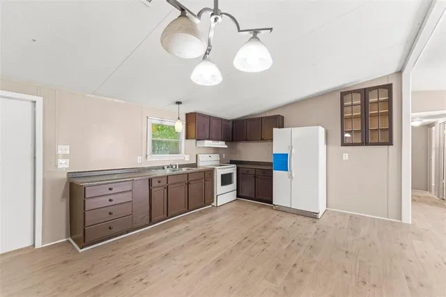 a large kitchen with a large window appliances and cabinets
