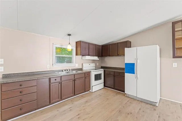 a kitchen with stainless steel appliances granite countertop a refrigerator sink and stove