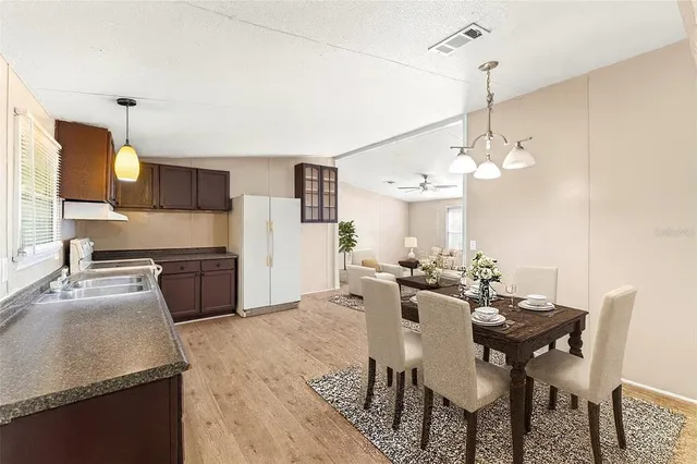 a view of a dining room and livingroom with furniture wooden floor a chandelier
