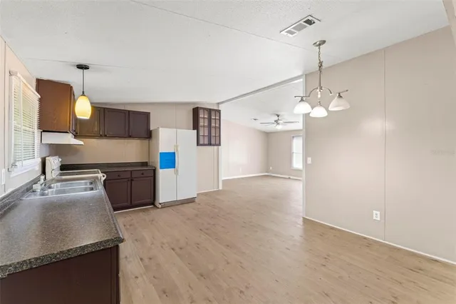 a kitchen with stainless steel appliances granite countertop a sink a stove and a refrigerator