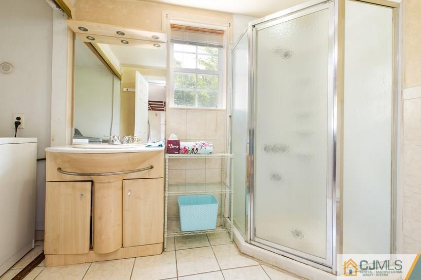 613 Old Post Road Edison, NJ 08817 - Photo 8 of 20 a bathroom with a sink a mirror and a shower