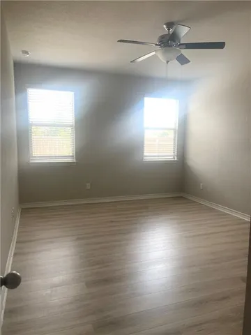an empty room with wooden floor and a window