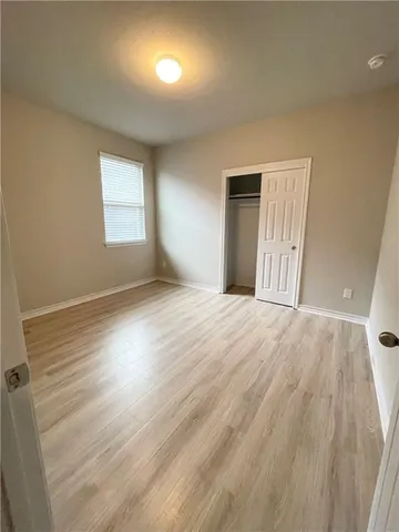 an empty room with wooden floor and closet