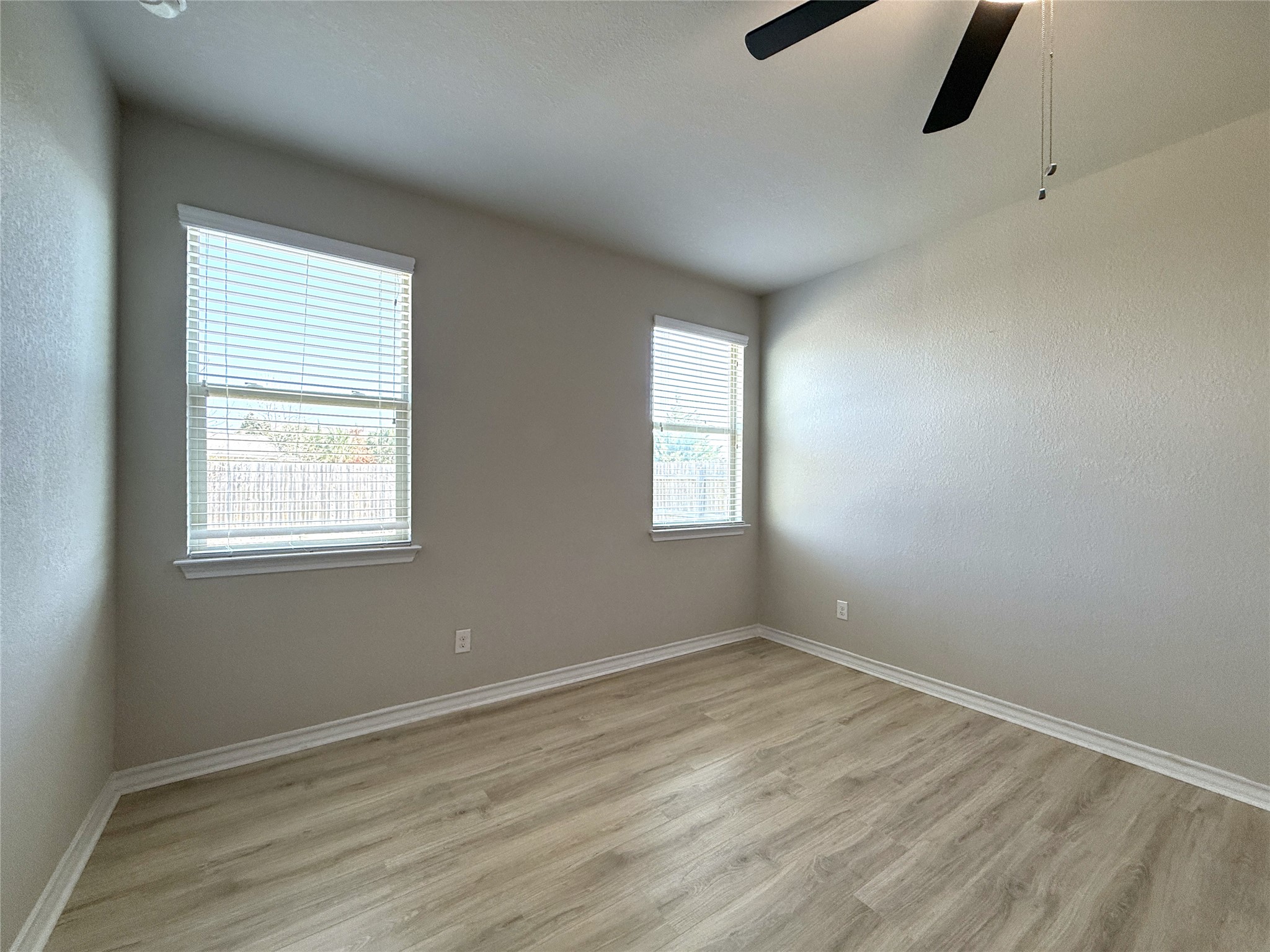 5989 Malta Circle Round Rock, TX 78665 - Photo 20 of 36 Spare room with light wood-style flooring, a ceiling fan, and a textured wall