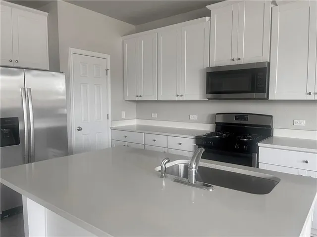 a kitchen with stainless steel appliances a refrigerator a stove a microwave and cabinets