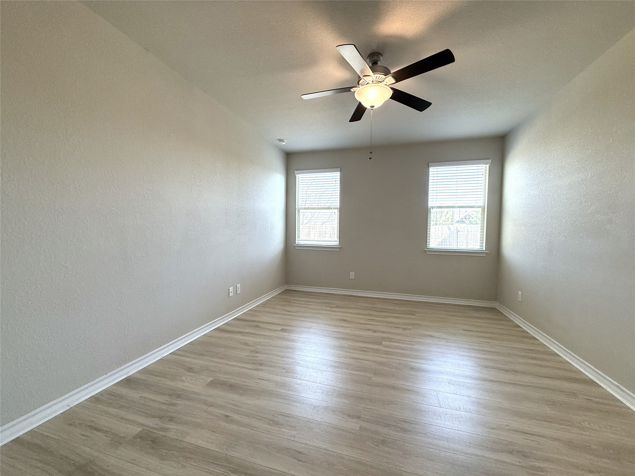 5989 Malta Circle Round Rock, TX 78665 - Photo 21 of 36 Spare room featuring a textured wall, ceiling fan, and light wood finished floors