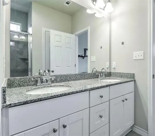 a bathroom with a granite countertop sink and shower
