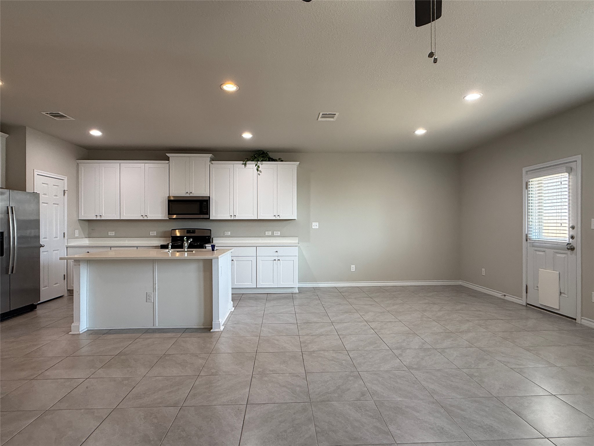 5989 Malta Circle Round Rock, TX 78665 - Photo 8 of 36 Kitchen with stainless steel appliances, a kitchen island with sink, white cabinets, recessed lighting, and ceiling fan
