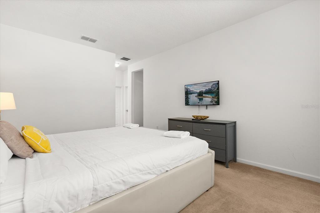 4565 Cabello Loop Kissimmee, FL 34746 - Photo 14 of 33 a bedroom with a bed and painting on the wall