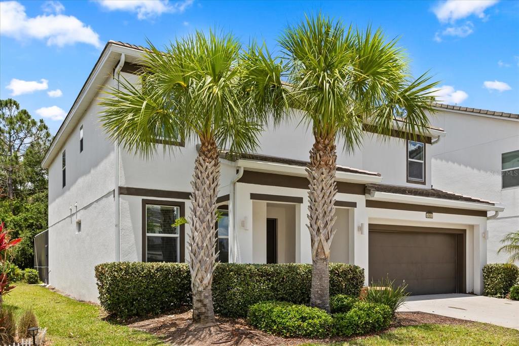 4565 Cabello Loop Kissimmee, FL 34746 - Photo 2 of 33 a palm tree in front of a house with potted plants