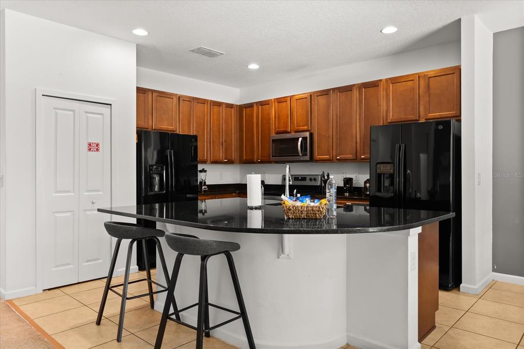 4565 Cabello Loop Kissimmee, FL 34746 - Photo 9 of 33 a kitchen with stainless steel appliances granite countertop a refrigerator and a stove top oven