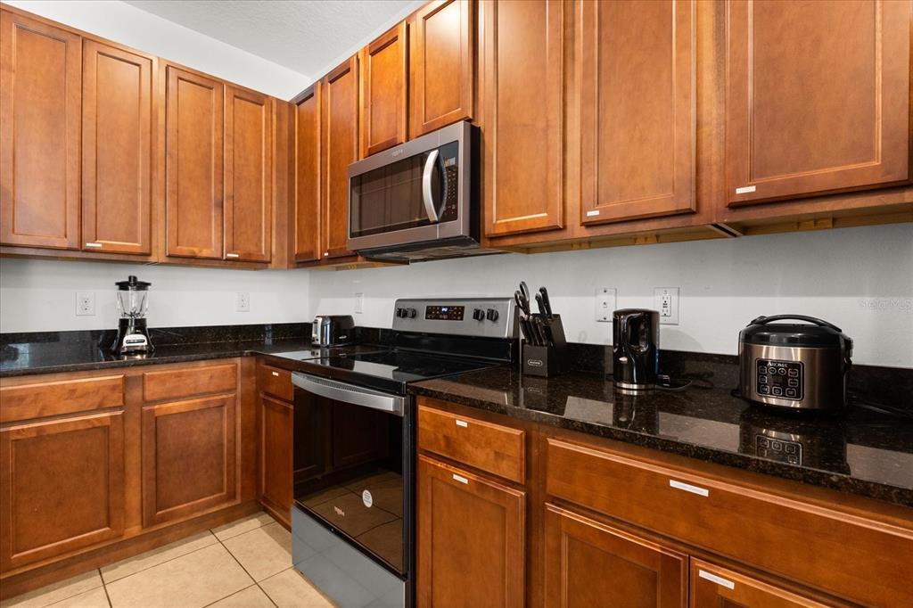 4565 Cabello Loop Kissimmee, FL 34746 - Photo 10 of 33 a kitchen with stainless steel appliances granite countertop a refrigerator sink and cabinets