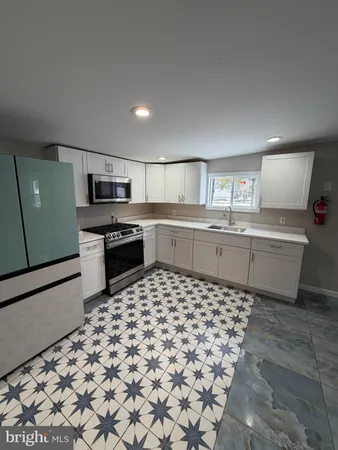 a kitchen with a sink a counter top space stainless steel appliances and cabinets