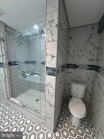 a bathroom with a toilet and a shower