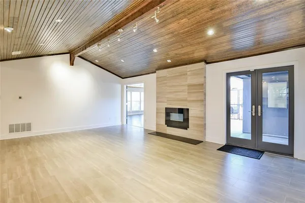 an empty room with wooden floor and fireplace