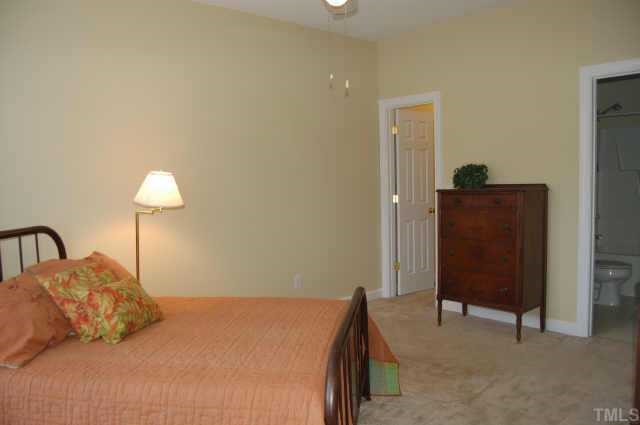 800 Rothshire Court Raleigh, NC 27615 - Photo 4 of 7 a bedroom with a bed and a lamp