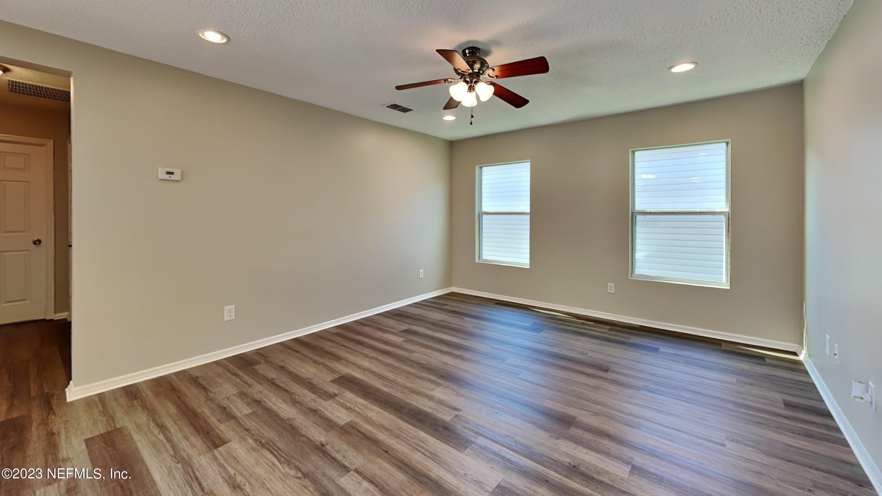 11907 Alexandra Drive Jacksonville, FL 32218 - Photo 2 of 14 a view of an empty room with wooden floor and a window