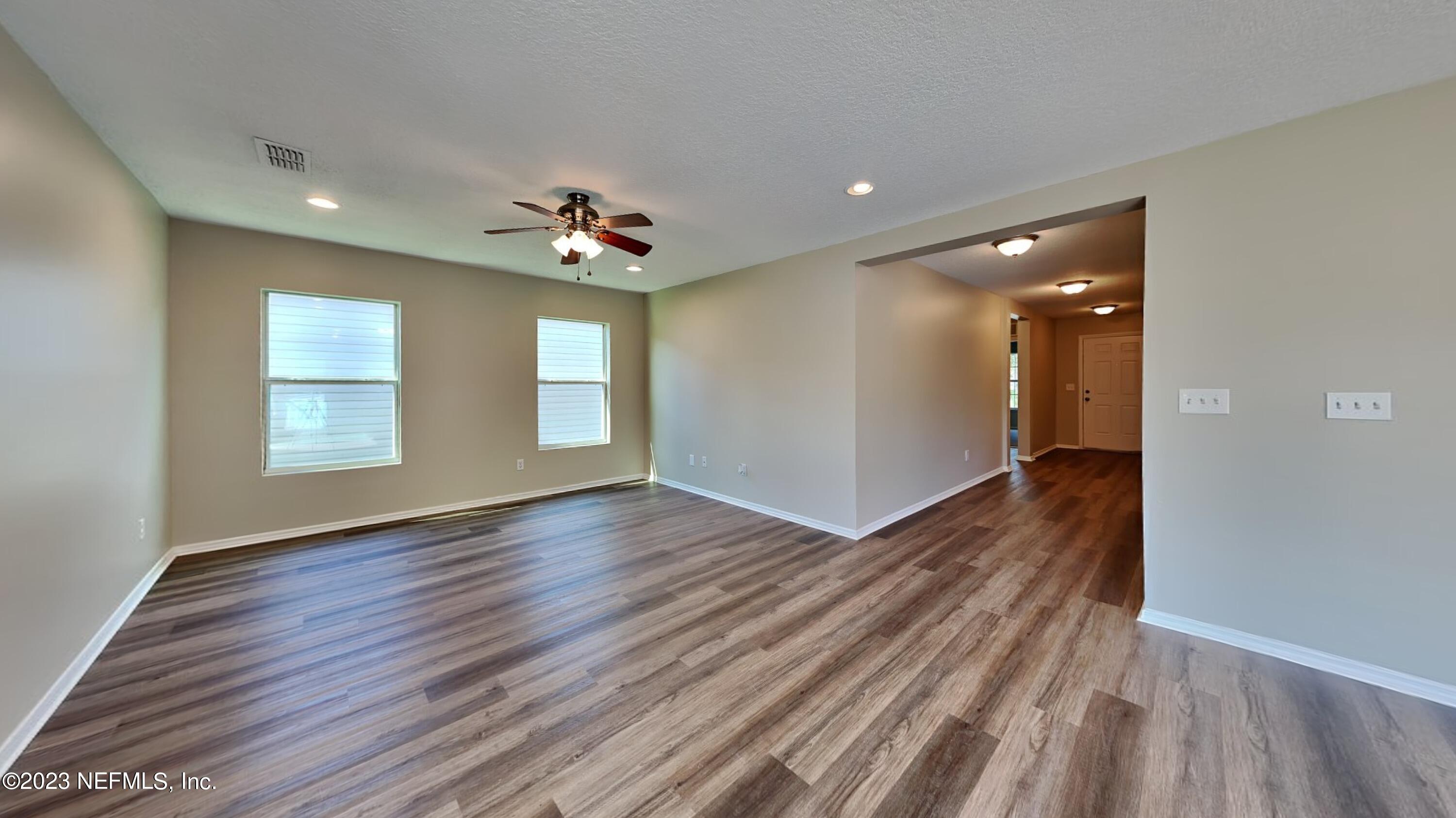 11907 Alexandra Drive Jacksonville, FL 32218 - Photo 3 of 14 a view of an empty room with wooden floor and a window