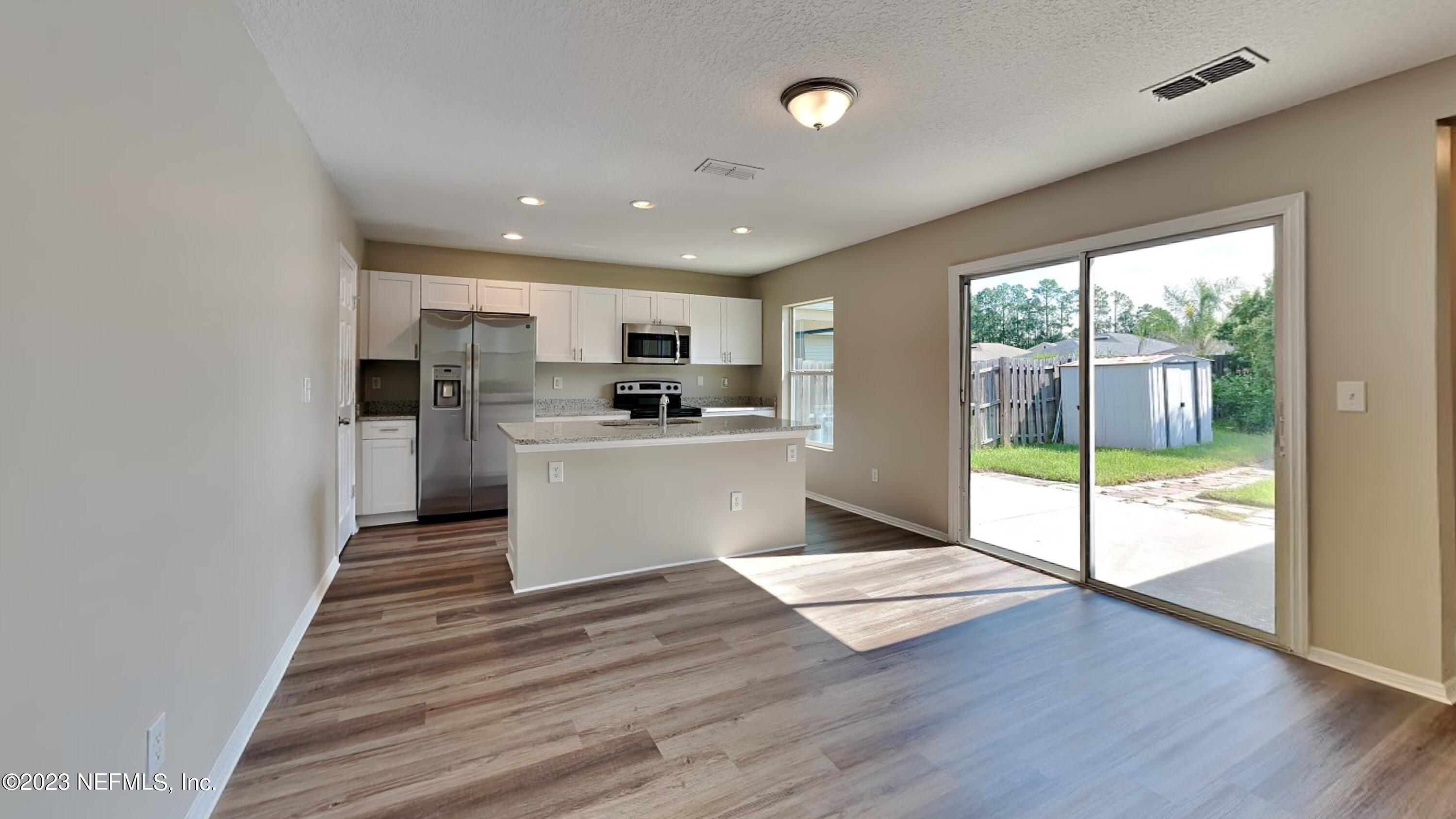 11907 Alexandra Drive Jacksonville, FL 32218 - Photo 4 of 14 a view of kitchen with refrigerator and wooden floor