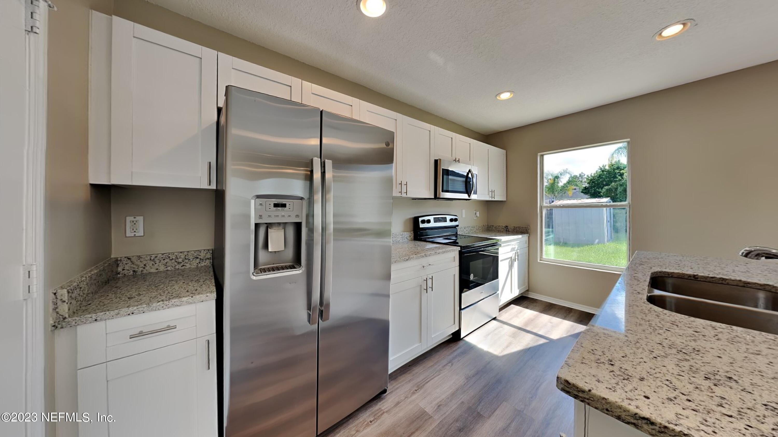 11907 Alexandra Drive Jacksonville, FL 32218 - Photo 5 of 14 a kitchen with stainless steel appliances granite countertop a refrigerator a stove and a sink