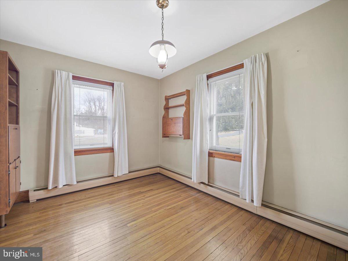 7220 Slabtown Road Waynesboro, PA 17268 - Photo 11 of 43 an empty room with wooden floor cabinet and windows